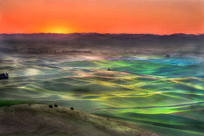 Sunrise over the Palouse with vivid orange horizon and pastel colors from reflection of light on the dew.