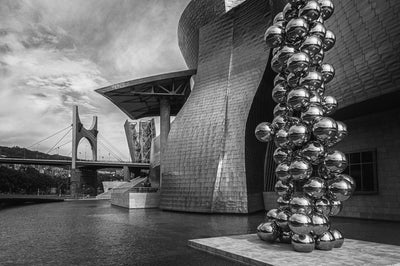 Black and white image of the outside of the Guggenheim Museum Bilbao.