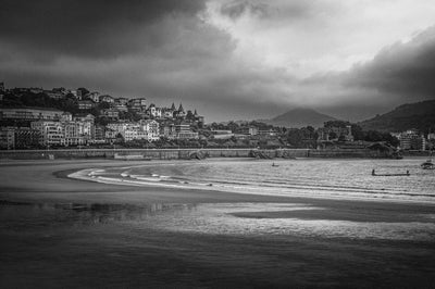 Black and white photo of the beach at San Sebastian with a storm rolling in. 