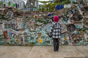 Girl with pink hair staring at mosaic wall in Philadelphia.